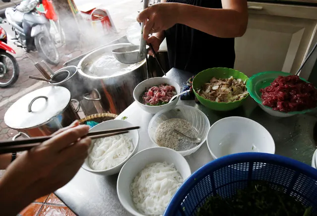 Women make the Vietnamese traditional beef noodle “Pho” at a breakfast restaurant in Hanoi, Vietnam July 18, 2018. (Photo by Reuters/Kham)