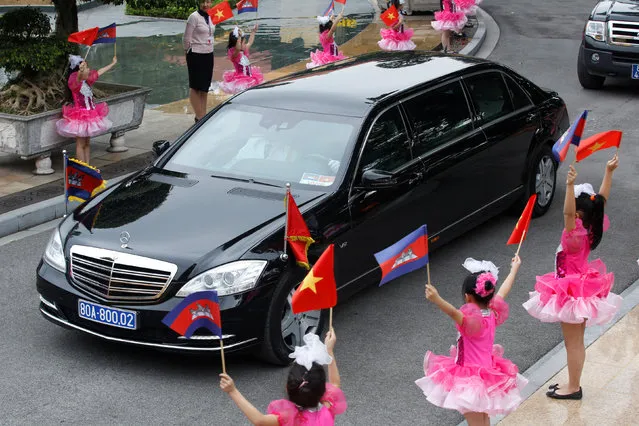Vietnamese school-girls wave Vietnamese and Cambodian flags as a limousine transports Cambodia's Prime Minister Hun Sen, at the Presidential Palace in Hanoi, Vietnam December 20, 2016. (Photo by Reuters/Kham)