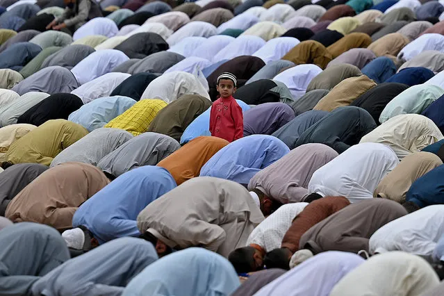 A child looks on as Muslim devotees offer special prayers on the occasion of Eid al-Fitr that marks the end of the holy month of Ramadan at Eidgah Sharif shrine in Rawalpindi on May 13, 2021. (Photo by Aamir Qureshi/AFP Photo)
