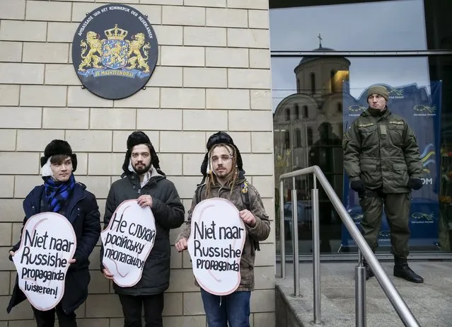 Activists dressed as the Dutch artist Vincent van Gogh demonstrate outside the Dutch embassy in Kiev, Ukraine, February 5, 2016. They demanded that Dutch people ignore what they say are Russian propaganda, ahead of an upcoming Dutch Ukraine-European Union Association Agreement. The signs read, “Don't listen to Russian propaganda”. (Photo by Gleb Garanich/Reuters)