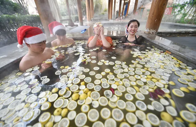 People wearing Santa hats bath with lemon slices at a hot spring center during the Christmas holiday on December 24, 2016 in Luoyang, Henan Province of China. Reportedly taking fruit bath keeps skin in good condition. (Photo by VCG via Getty Images)