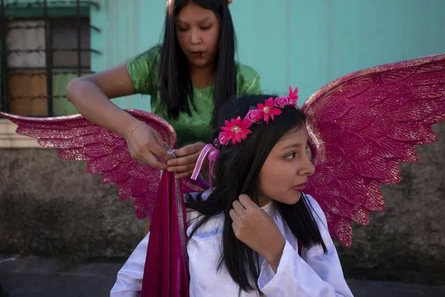 Jennifer Lopez, top, and her sister Jessica adjust their angel costumes prior to a procession symbolizing the fight between good and evil to celebrate the Virgin of the Immaculate Conception in Ciudad Vieja, Guatemala, Friday, December 7, 2018. Catholics hold their neighbor days-long annual fair in honor of their patron saint, the Virgin of the Immaculate Conception, whose official feast day is Dec. 8. (Photo by Santiago Billy/AP Photo)