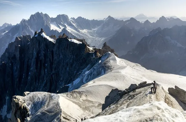 Alpinists Mat Cooper and Daniel Trevena start a tour to Les Cosmiques from the Aiguille du Midi during a heatwave in the Mont-Blanc region in Chamonix, France on August 23, 2023. (Photo by Denis Balibouse/Reuters)