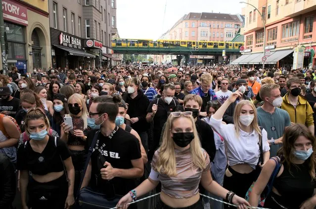 People, most of them wearing masks, dance behind a truck as they attend a demonstration named “Train of Love” in Berlin, Germany, Saturday, August 28, 2021. Protesters have filled the German capital, as thousands turned out to demonstrate against the government’s coronavirus measures despite bans against several planned gatherings. (Photo by Markus Schreiber/AP Photo)