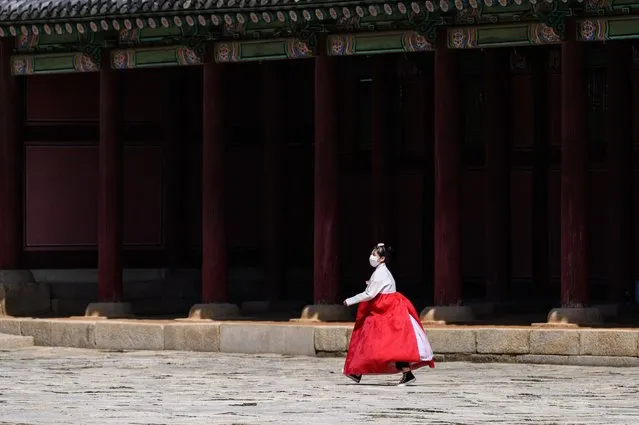 A visitor wears traditional hanbok dress at the Gyeongbokgung Palace in Seoul on September 20, 2021, a day before the Chuseok holiday. (Photo by Anthony Wallace/AFP Photo)