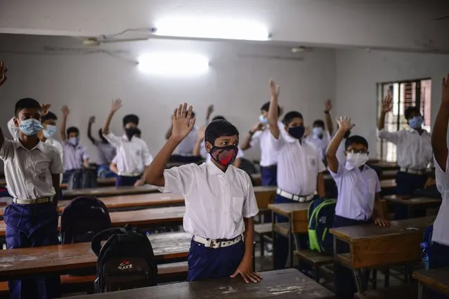 Students attend a class at the Narinda Government High School as schools reopen after being closed for nearly 18 months due to the coronavirus pandemic in Dhaka, Bangladesh, Sunday, September 12, 2021. (Photo by Mahmud Hossain Opu/AP Photo)