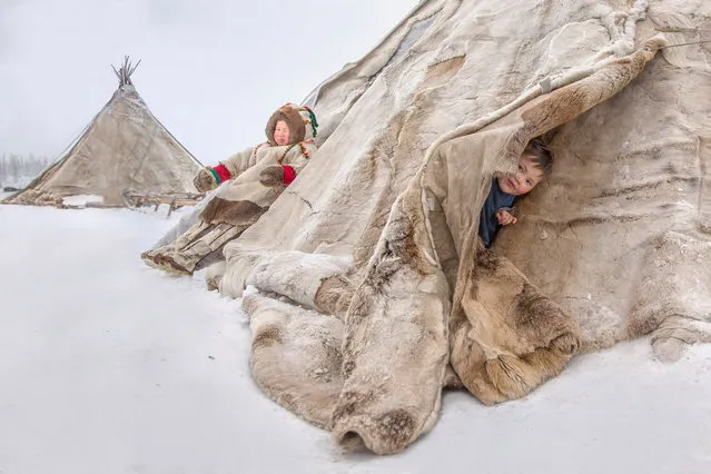 Kids are pictured in the Nenets, which consist of long sticks, and stitched reindeer skins stretched over it, pictured by Vladimir Alekseev in Russia, Yamal Peninsula. (Photo by Vladimir Alekseev/Travel Photographer of the Year)