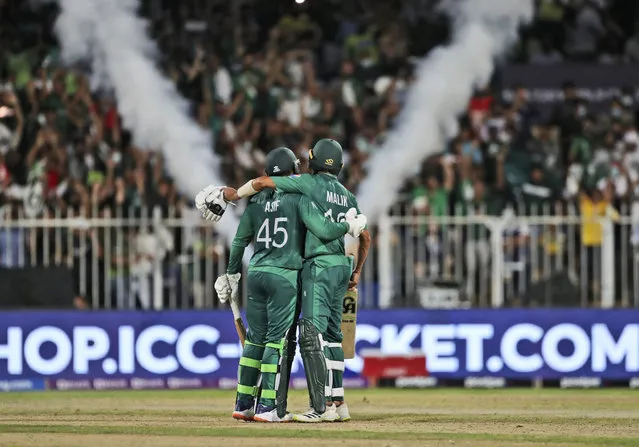 Pakistan's Asif Ali, left, and Pakistan's Shoaib Malik celebrate scoring runs just before their win during the Cricket Twenty20 World Cup match between New Zealand and Pakistan in Sharjah, UAE, Tuesday, October 26, 2021. (Photo by Aijaz Rahi/AP Photo)