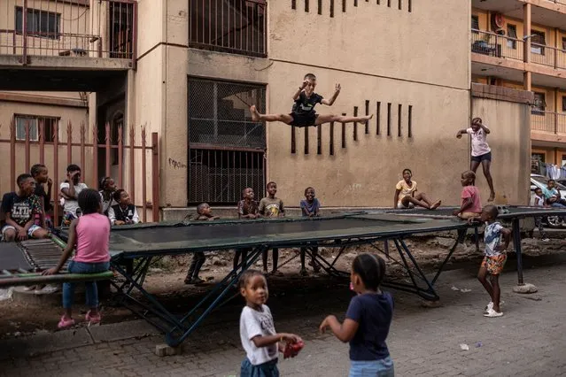 A child jumps on a trampoline as others wait their turn in Alexandra near Johannesburg on March 9, 2024. (Photo by Emmanuel Croset/AFP Photo)