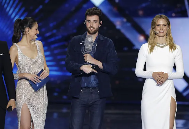 Duncan Laurence of the Netherlands is watched by presenters Lucy Ayoub, left, and Israeli mode Bar Refaeli as he holds the trophy after winning the 2019 Eurovision Song Contest grand final with the song “Arcade” in Tel Aviv, Israel, Saturday, May 18, 2019. (Photo by Sebastian Scheiner/AP Photo)
