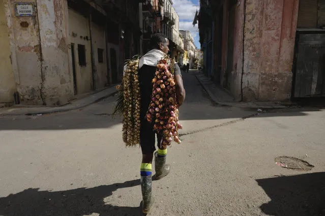 A street vendor walks through Old Havana selling onions and garlic, in Havana, Cuba, Wednesday, January 31, 2024. (Photo by Ramon Espinosa/AP Photo)
