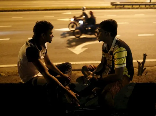 Spectators chat while they wait for the motorbike racing on a highway in Kuala Lumpur, Malaysia, July 26, 2015. (Photo by Olivia Harris/Reuters)