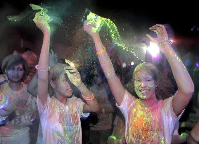 Participants covered in coloured powder during the Color Miles for Smiles 2016 run at Lumpini Park in Bangkok, Thailand, April 9, 2016. The five kilometer long color run is held to raise funds for a non-profit charity, Operation Smile Thailand, that to provides free medical treatment and surgeries for cleft lips, cleft palates also other facial deformities for Thai children. (Photo by EPA/Stringer)