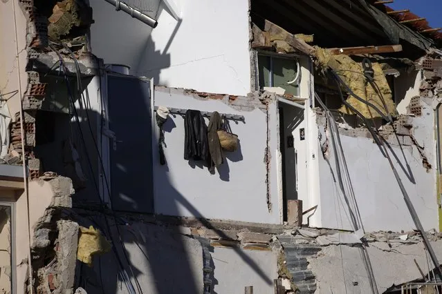 Jackets and a basket hang after a three-story apartment building collapsed in a suspected gas explosion on southern France's Mediterranean coast. Tuesday, December 7, 2021 in Sanary-sur-Mer. French rescue workers dug out the body of a man but also pulled a toddler and the child's mother alive from the rubble of the building that collapsed in a suspected gas explosion. Two other people are missing. (Photo by Daniel Cole/AP Photo)