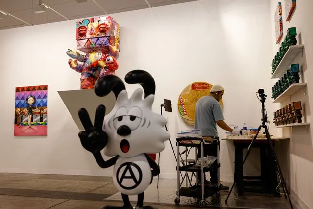 An artist works on his work at Art Basel in Hong Kong, China on March 26, 2024. (Photo by Tyrone Siu/Reuters)