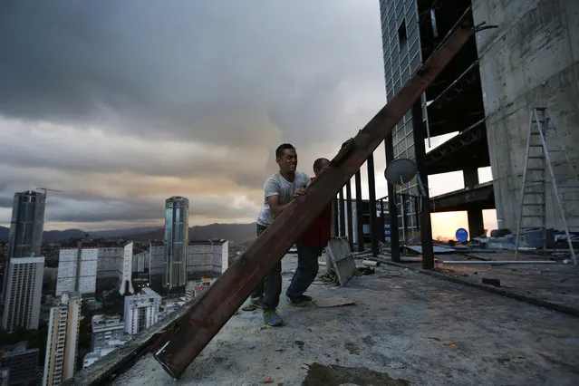 Men salvage metal on the 30th floor of the “Tower of David” skyscraper in Caracas February 3, 2014. (Photo by Jorge Silva/Reuters)