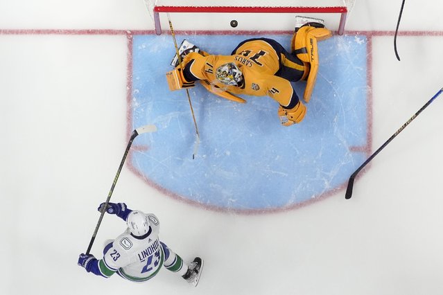 Vancouver Canucks center Elias Lindholm (23) scores a goal past Nashville Predators goaltender Juuse Saros (74) in overtime during Game 4 of an NHL hockey Stanley Cup first-round playoff series Sunday, April 28, 2024, in Nashville, Tenn. The Canucks won 4-3. (Photo by George Walker IV/AP Photo)