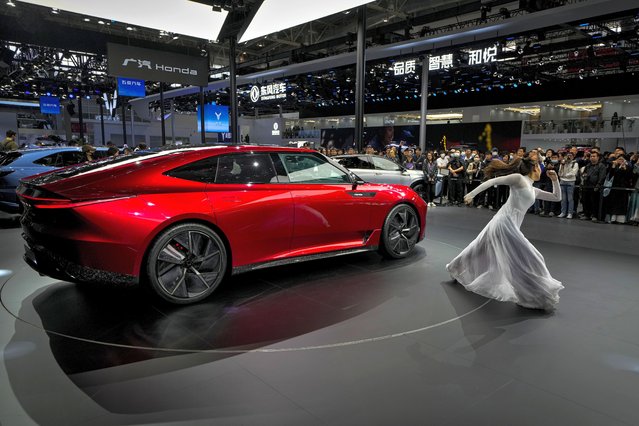 Visitors watch an artist perform dance near a Honda GT on stage during the Auto China 2024 in Beijing, Sunday, April 28, 2024. (Photo by Andy Wong/AP Photo)