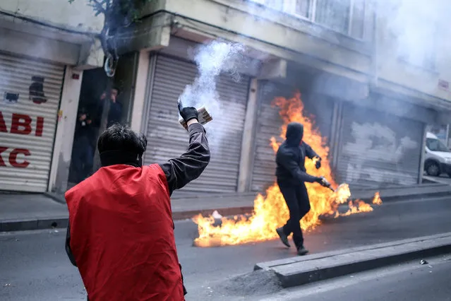 Leftist demonstrators throw petrol bombs as they clash with riot police using tear gas to disperse them during May Day celebrations in Istanbul, Sunday, May 1, 2016. Security forces prevented leftist groups trying to reach city's iconic Taksim Square to celebrate May Day. (Photo by Cagdas Erdogan/AP Photo)
