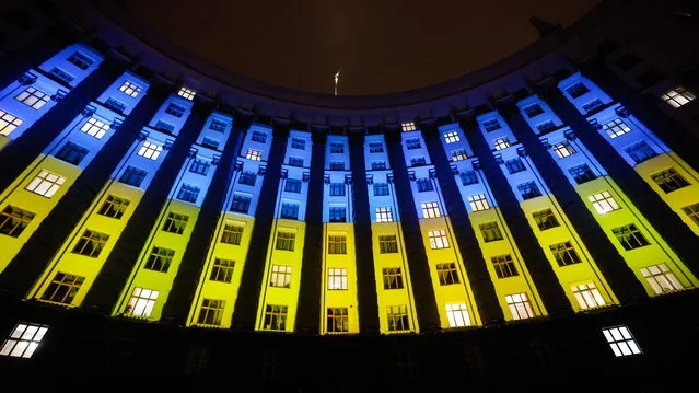 The building of Ukraine's cabinet of ministers is illuminated with the colors of the Ukrainian flag on a national Day of Unity in Kyiv on February 16, 2022. (Photo by Serhii Nuzhnenko/Radio Free Europe/Radio Liberty)