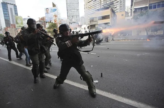 A Bolivarian National Guard officer fires teargas toward demonstrators during a protest in Caracas, Venezuela, Thursday, April 6, 2017. (Photo by Ariana Cubillos/AP Photo)