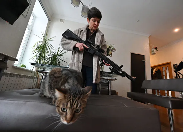 Mariana Jaglo, mother-of-three, holds her Ukrainian Z-15 – Zbroyar long rifle during an interview in the kitchen of her  flat in Kiev on January 28, 2022. As fears grow of a potential invasion by Russian troops massed on Ukraine's border, this 52-year-old army reservist, insists in her willing to fight to defend her country. (Photo by Sergei Supinsky/AFP Photo)