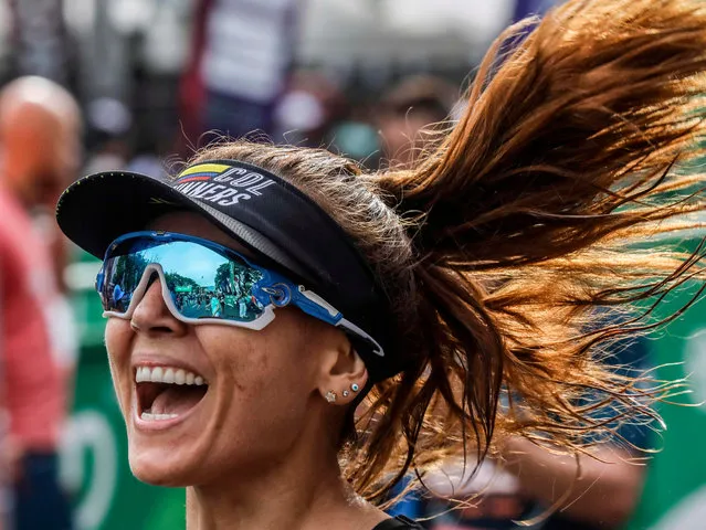 A runner celebrates at the end of teh 2ikm race of the Medellin Flowers Marathon, in Medellin, Colombia, on September 8, 2019. (Photo by Joaquín Sarmiento/AFP Photo)