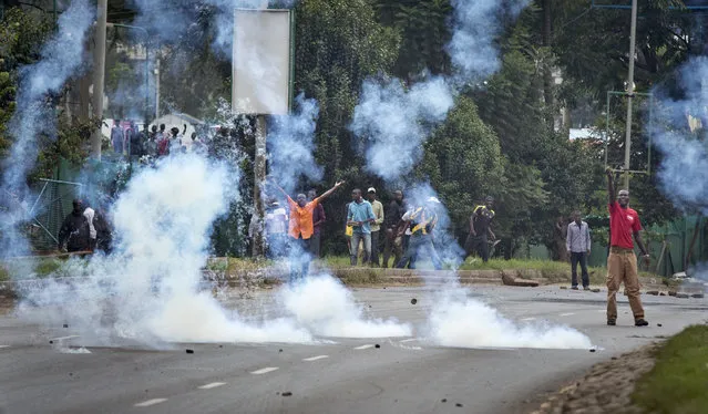 Tear gas canisters rain down next to opposition supporters as they taunt riot police during a protest in downtown Nairobi, Kenya Monday, May 9, 2016. (Photo by Ben Curtis/AP Photo)