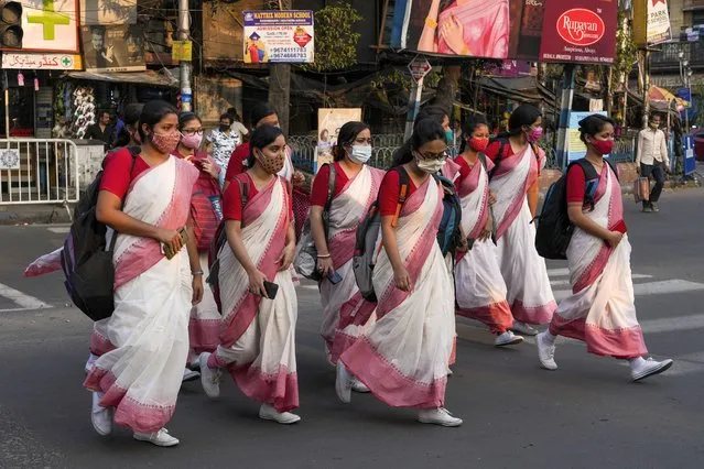 A group of Indian students wearing face masks as a precaution against the coronavirus return from their school in Kolkata, India, Thursday, March 3, 2022. Slowly but steadily, life in South Asia is returning to normal, and people hope the worst of the COVID-19 pandemic is behind them. Experts are optimistic that the omicron surge, which brought relatively low levels of death, has reinforced immunity from vaccines, which are widespread in the region. (Photo by Bikas Das/AP Photo)