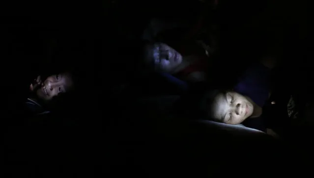 Flood victims use electronic devices as they rest at an evacuation center after their homes were inundated as Tropical storm Fung-Wong battered the Philippine capital Manila September 19, 2014. (Photo by Erik De Castro/Reuters)