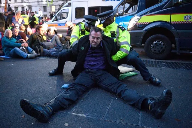 Extinction Rebellion climate change protesters are arrested as they demonstrate in Whitehall in London, Britain, 08 October 2019. Global climate movement Extinction Rebellion announced climate change protests and blockades worldwide for two weeks starting 07 October. (Photo by Neil Hall/EPA/EFE)