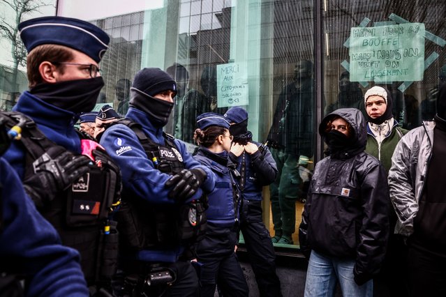 Police officers stand in front of a building where migrants and members of NGO stand inside a former federal building to demand from the government an emergency solution for their situation, Brussels, Belgium, 14 March 2023. Since 12 March, about seventy asylum seekers who have not been able to obtain a place in the reception network and have been on the street for several days have taken possession of an unoccupied building. (Photo by Stephanie Lecocq/EPA/EFE/Rex Features/Shutterstock)