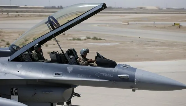 Iraq's Defence Minister Khaled al-Obeidi (L) sits in a F-16 fighter jet, during an official ceremony to receive four of these aircrafts from the U.S., at a military base in Balad, Iraq, July 20, 2015. (Photo by Thaier Al-Sudani/Reuters)