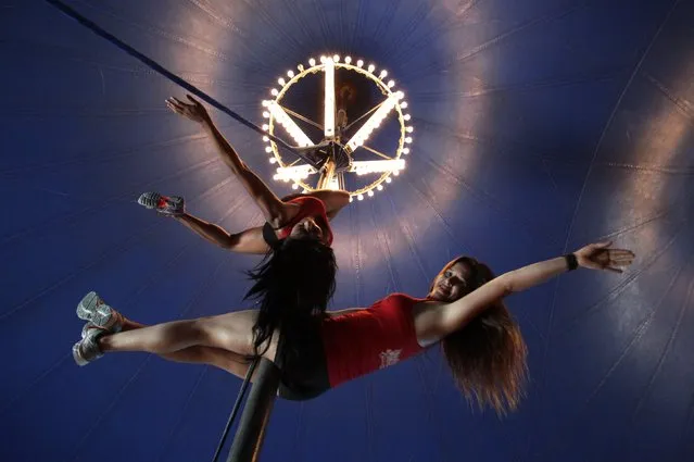 Women perform a pole dancing routine at a circus during the national day celebration of “Urban Pole” dance in Monterrey June 8, 2014. (Photo by Tomas Bravo/Reuters)