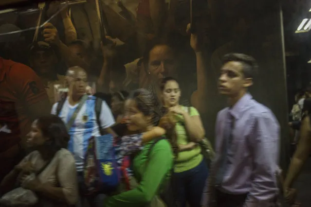 Commuters wait to board a crowded subway car in Caracas, Venezuela, Tuesday, July 16, 2019. (Photo by Rodrigo Abd/AP Photo)
