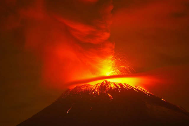 Incandescent materials, ash and smoke are spewed from the Popocatepetl volcano as seen from the San Nicolas de los Ranchos community, state of Puebla, Mexico, on May 23, 2023. Mexican authorities on May 21 raised the warning level for the Popocatepetl volcano to one step below red alert, as smoke, ash and molten rock spewed into the sky posing risks to aviation and far-flung communities below. Sunday's increased alert level – to “yellow phase three” – comes a day after two Mexico City airports temporarily halted operations due to falling ash. (Photo by Rafael Duran/AFP Photo)