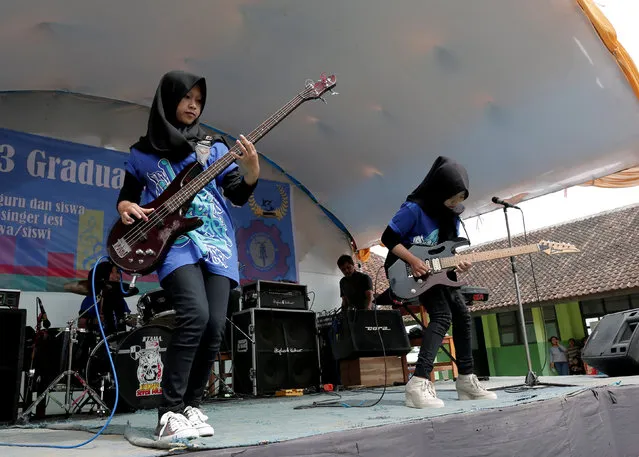 Widi Rahmawati (L) and Firdda Kurnia, members of the metal Hijab band Voice of Baceprot, perform during a school's farewell event in Garut, Indonesia, May 15, 2017. (Photo by Yuddy Cahya/Reuters)