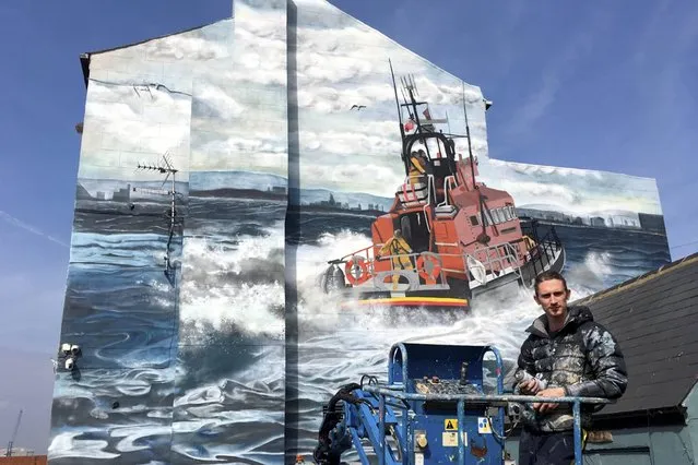 Mural artist Lewis Hobson, who has completed a wall mural in tribute to life-saving RNLI volunteers on the gable end of the Ship Inn pub in Hartlepool on April 17, 2022. (Photo by RNLI/North News)