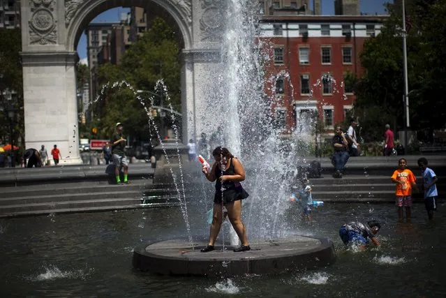 Children cool off in a fountain in Washington Square Park in the Manhattan borough of New York City on a hot summer day August 4, 2015. (Photo by Mike Segar/Reuters)