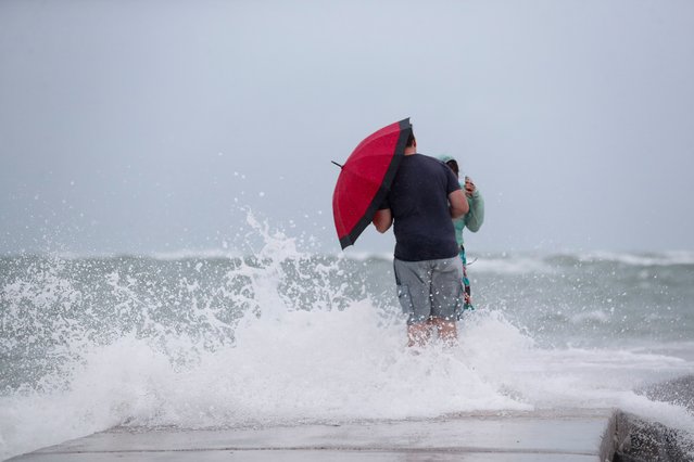 A couple stands on the John's Pass Pier, while Tropical Storm Debby approaches the gulf coast in Madeira Beach, Florida on August 4, 2024. (Photo by Octavio Jones/Reuters)