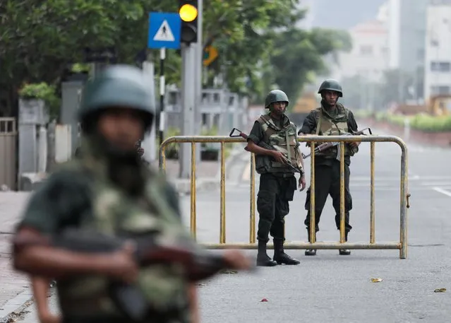 Army soldiers stand guard at a checkpoint near the Prime Minister's official residence after the government imposed a three-day curfew following clashes between pro and anti-government demonstrators, amid the country's economic crisis, in Colombo, Sri Lanka, May 10, 2022. (Photo by Dinuka Liyanawatte/Reuters)