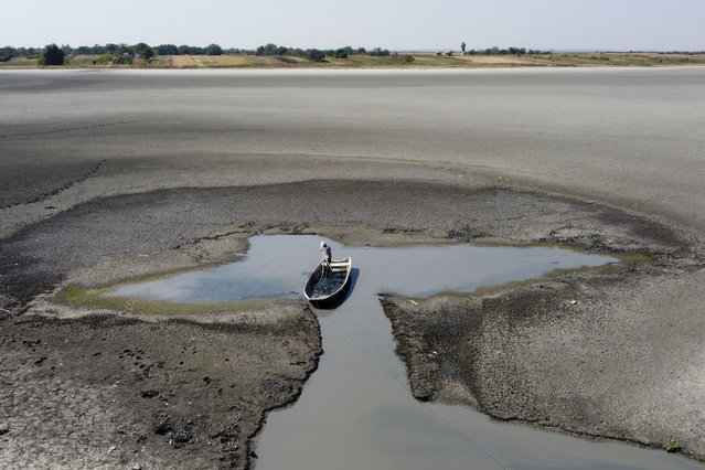 A man collects mud that is used in medical therapy at the dried out Rusanda salty lake, near Melenci, Serbia, Wednesday, September 4, 2024. (Photo by Darko Vojinovic/AP Photo)