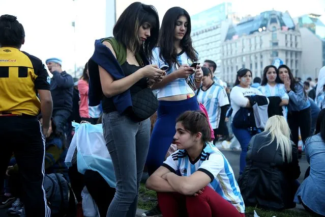Argentine soccer fans listen to a broadcast of the second half of the World Cup final on July 13, 2014 in Buenos Aires, Argentina. (Photo by Joe Raedle/Getty Images)