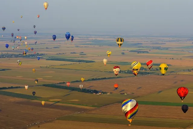 Hot air balloons fly during the 19th FAI Hot Air Balloon European Championship in Debrecen, 226 kms east of Budapest, Hungary, August 12, 2015. Hundred and two contestants of twenty-three countries participate in the event through August 18. (Photo by Zsolt Czegledi/EPA)