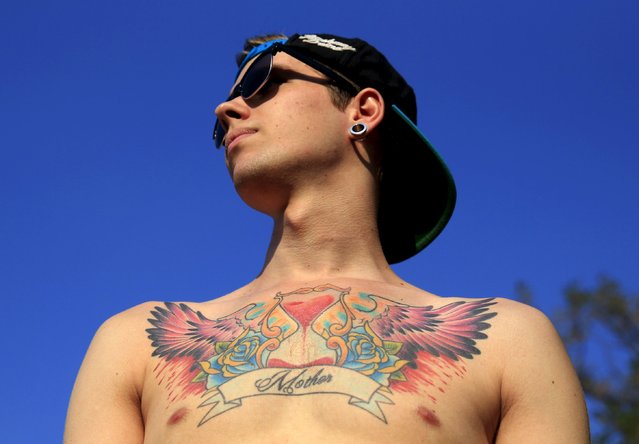 David Noel, 21, from Hungary shows his tattoo during the Sziget music festival on an island in the Danube River in Budapest, Hungary, August 14, 2015. (Photo by Bernadett Szabo/Reuters)