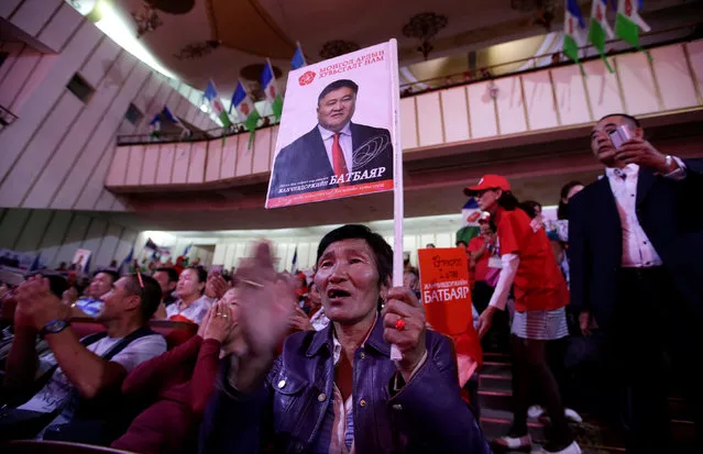 A woman holding a picture of a candidate from Mongolian People's Revolutionary Party (MPRP) attends a rally for the upcoming parliamentary elections in Ulan Bator, Mongolia, June 26, 2016. (Photo by Jason Lee/Reuters)