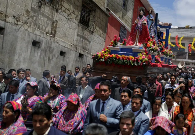People carry an image of San Pedro (in red) during an annual procession honoring San Pedro, their town's patron saint, through the streets of San Pedro Sacatepequez near Guatemala City June 29, 2016. (Photo by Saul Martinez/Reuters)