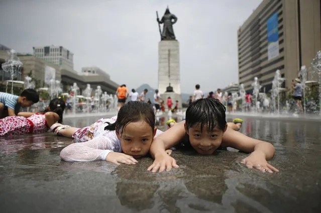 Children play in a fountain to cool down on a hot summer day in front of the General Lee Soon-shin statue in Gwanghwamun, Seoul July 28, 2014. (Photo by Kim Hong-Ji/Reuters)