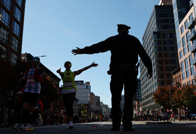 A police officer with runners in the Brooklyn borough of New York City during the marathon in New York on November 3, 2024. (Photo by Maye-E Wong/Reuters)