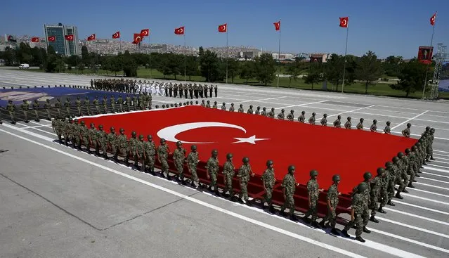 Turkish soldiers carry a huge national flag and a portrait of Mustafa Kemal Ataturk, founder of modern Turkey, during a military parade marking the 93rd anniversary of Victory Day in Ankara, Turkey, August 30, 2015. (Photo by Umit Bektas/Reuters)